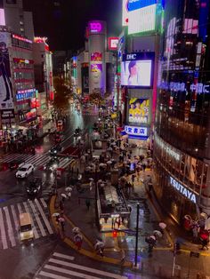 a city street filled with lots of traffic and people walking across the street at night