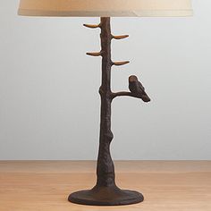 a lamp that is on top of a table with a bird perched on the branch