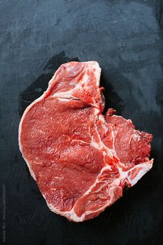 raw meat is shown on a black surface