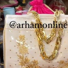 a white purse with gold chains hanging from it