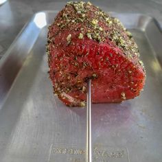 a piece of meat on a metal tray with a toothpick in the middle