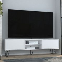 a flat screen tv sitting on top of a white entertainment center