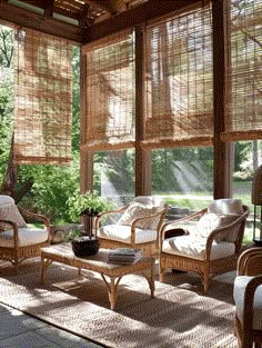 a living room with wicker furniture and large windows