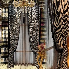 a room with zebra print curtains and a chandelier