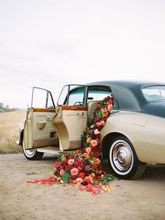 an old car is decorated with flowers and ribbons