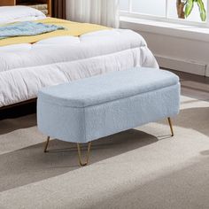 a blue bench sitting in front of a bed on top of a carpeted floor