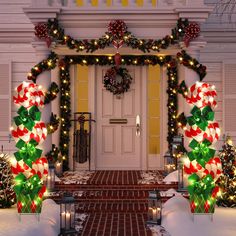 christmas decorations on the front door of a house with lights and candy canes all around