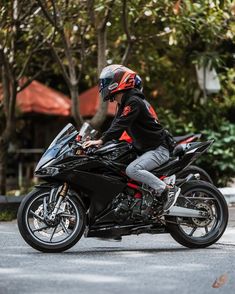 a man riding on the back of a black motorcycle