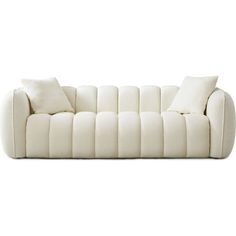 a white couch sitting on top of a white floor next to a pillow and pillows