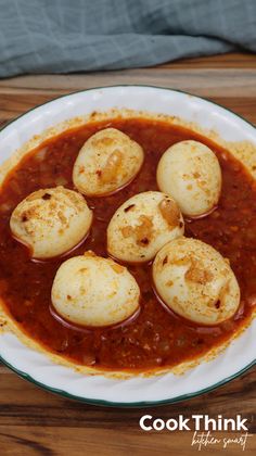 some kind of food that is on a white and green plate with red sauce in it