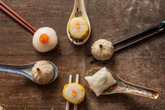 chopsticks and dumplings are arranged on a wooden table