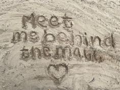 the words meet me at the beach written in sand