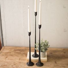 three candles are sitting on a wooden table