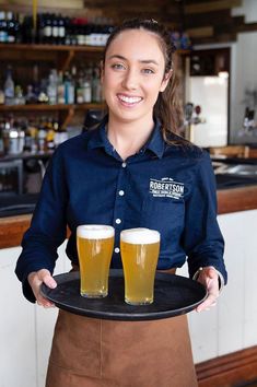 The crew at Robertson Pub in country NSW have been serving up the cold beers since 1887🍻 The team look fresh & sharp in Navy Cargo Crew Smith Oxford Shirts with bold embroidery to make their logo stand out strong & proud. The colour combo of Navy & Tobacco Apron is a nice touch, giving a modern take on classic styling👌 | Pub Uniform | Waiters Uniform | Bar Staff Waitress Outfits Casual, Waiters Uniform, Waiter Uniform Design, Waiter Outfit, Bar Uniform, Waitress Outfit