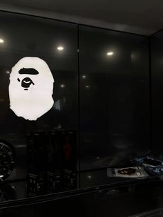 a large white gorilla head on the side of a glass wall in front of a record player