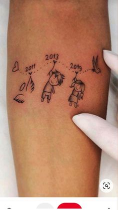 a woman's arm with a tattoo on it that says 2013 and two children