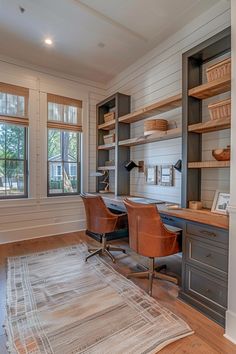 a home office with built in shelving, desk and chair next to a window