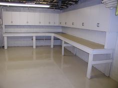 an empty locker room with benches and cabinets