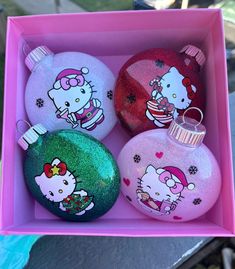 three hello kitty ornaments in a pink box