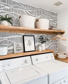 a washer and dryer in a room with wallpaper on the walls behind them