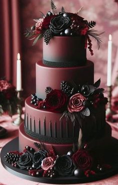 a three tiered cake with flowers and berries on the top is surrounded by candles