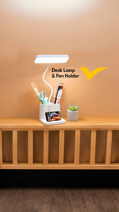 a desk lamp and pen holder sitting on top of a wooden shelf