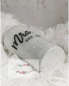 a close up of a bottle on a white fur covered surface with the word love written on it