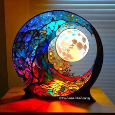 a stained glass sculpture with a full moon in the background