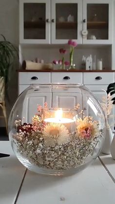 a vase filled with flowers and a lit candle