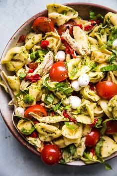 a bowl full of pasta salad with tomatoes, broccoli and mozzarella