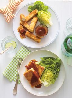 two white plates with food on them sitting next to each other