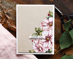 a close up of a card with flowers on it and scissors next to the card