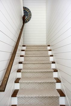 the stairs in this house have been painted white and are decorated with beige herringbone carpet