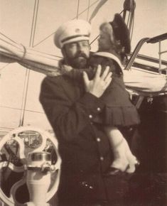 an old photo of a man and woman kissing on the back of a boat,