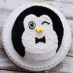 a cake decorated with a penguin face and bow tie