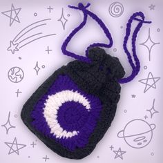 a crocheted purple and black bag with a white eyeball on the front