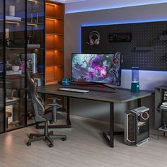 a computer desk with a monitor, keyboard and speakers sitting on top of it in front of a bookcase