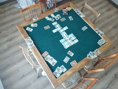 an overhead view of a dining room table with cards laid out on it and chairs around the table