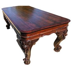 an old wooden table with ornate carvings on it's legs and wood grained edges