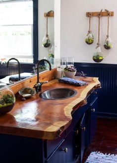 the kitchen counter top is made out of wood and has two sinks in front of it