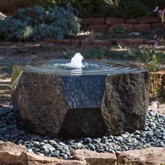 a water fountain surrounded by rocks and gravel