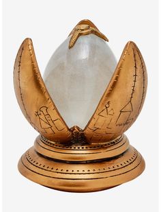 a golden clock with a glass ball in it's center and two hands on top