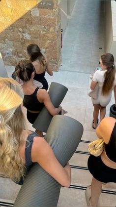 several women standing in a circle with yoga mats on their backs