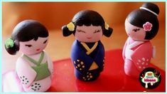 three small figurines sitting on top of a red table