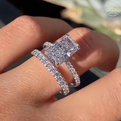 a woman's hand with two engagement rings on it