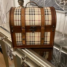 an old fashioned suitcase sitting on top of a glass table in front of a mirror