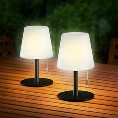 two lamps sitting on top of a wooden table