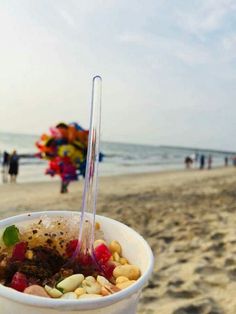 a bowl of cereal on the beach with people in the background