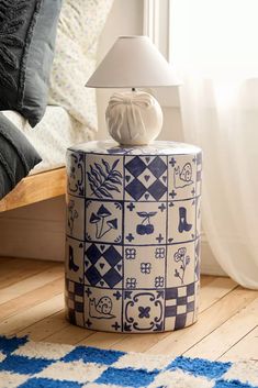 a blue and white vase sitting on top of a wooden floor next to a window