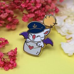 a white cat wearing a blue hat and holding a purple bat on top of pink flowers